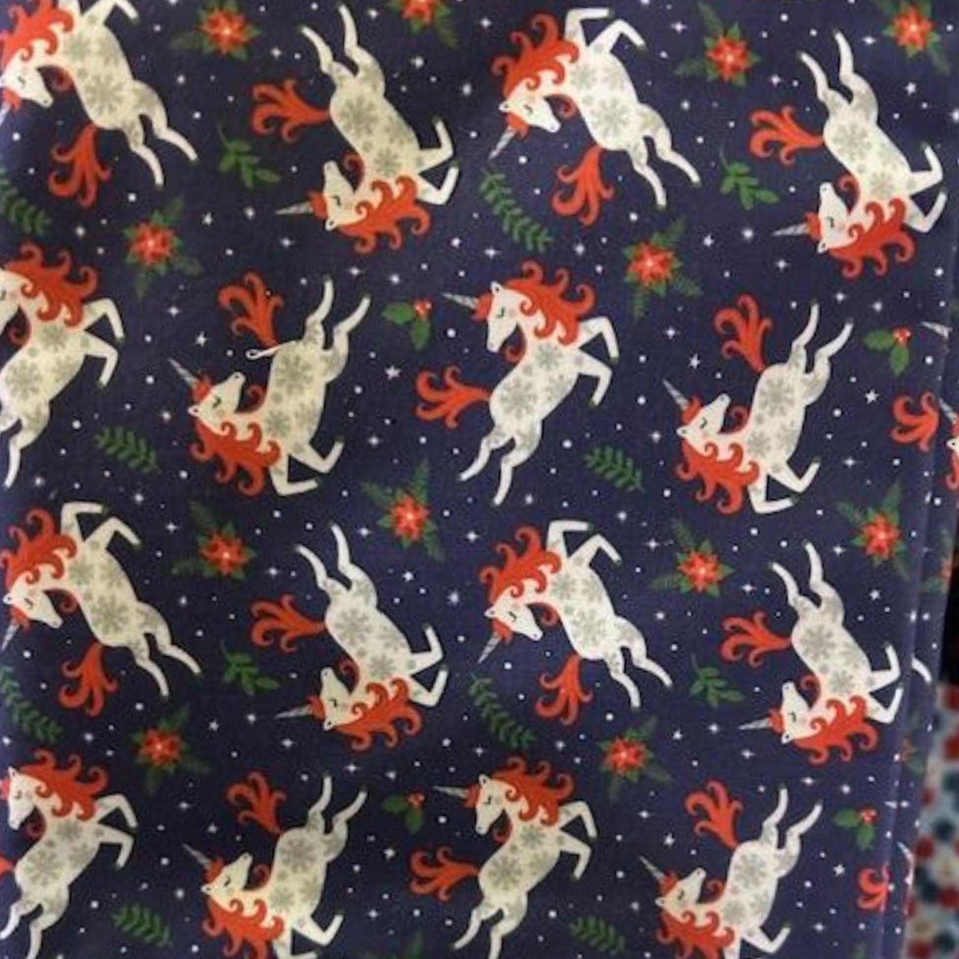 Camelot Holiday Unicorns fabric on navy with poinsettias, 100% cotton Christmas unicorn print